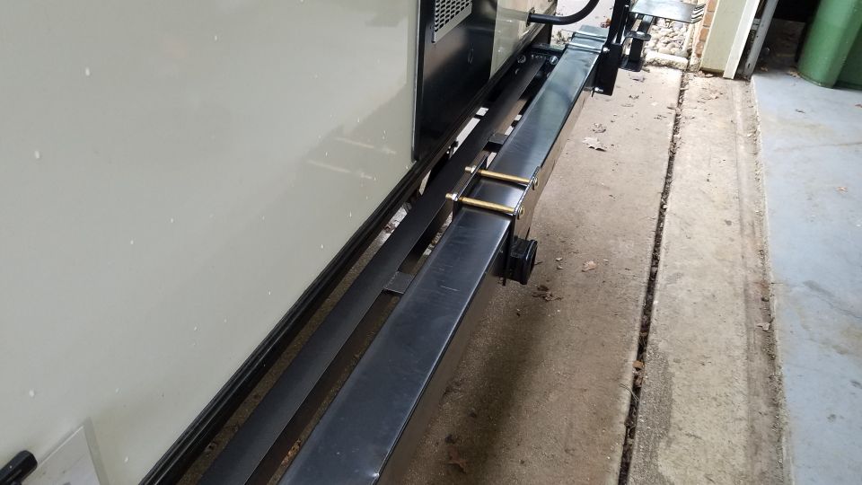 Welded steel beam or rail fixture being fabricated in a workshop beside a wall
