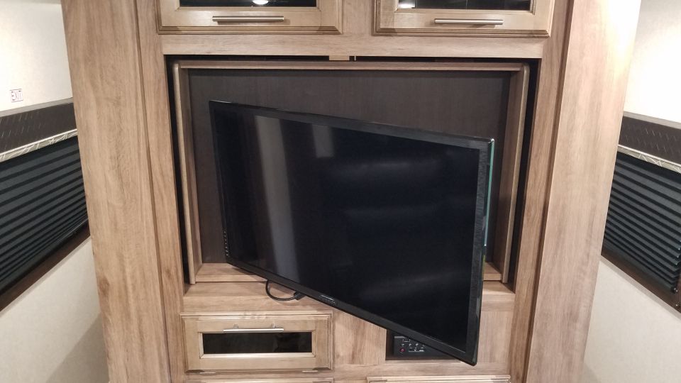 Television mounted in a wooden entertainment center.