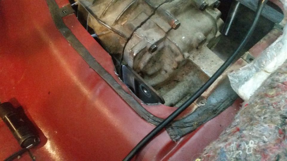 Vehicle transmission tunnel with custom bracket attached to transmission.