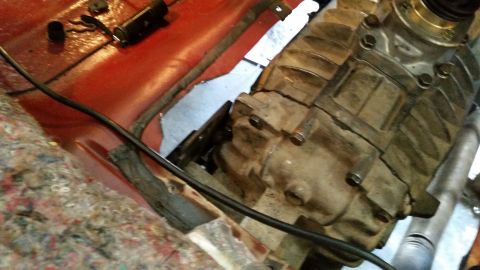 1985 Ford Bronco - A close-up view of a vehicle's transmission housing, likely from an older 4x4, showing bolts and mounting points. The surrounding area incl…
