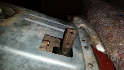 1985 Ford Bronco - A close-up view of a metal component with a lever protruding from a rectangular cutout. The lever has two circular holes and appears to be…