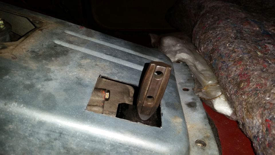 Close-up of a metal lever with two holes protruding from a cutout.