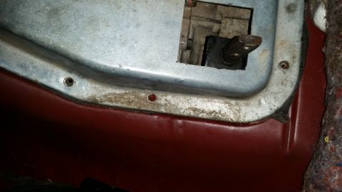 1985 Ford Bronco - Close-up of the transmission tunnel interior, showing the shifter mechanism and surrounding metalwork.