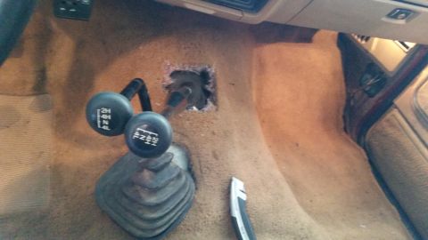 1985 Ford Bronco - Center console of a 1985 Ford Bronco, two gear shifters and a modified transmission tunnel opening.