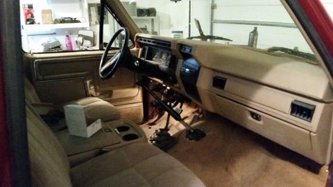 1985 Ford Bronco - The interior of a 1985 Ford Bronco, its dashboard, seats, and manual transmission, is visible in this registry photo.