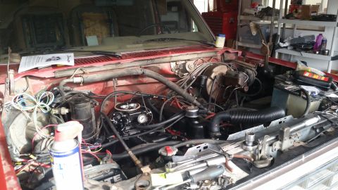 1985 Ford Bronco - Engine bay of a 1985 Ford Bronco, showing the carburetor and various engine components.
