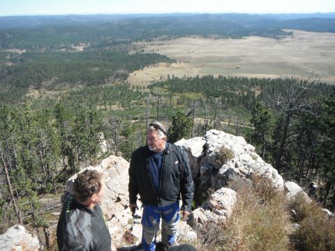 1987 Honda XL600R - Two men on a rocky overlook with a vast landscape behind them. The image has a watermark for SUPERMOTORS.