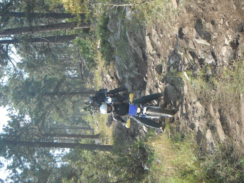 Motorcycle on rocky trail with another motorcycle behind it