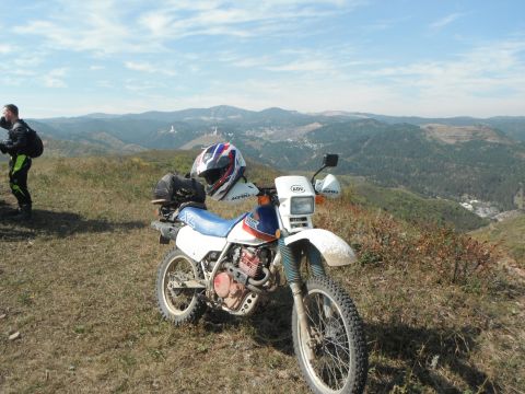 1987 Honda XL600R - 1987 Honda XL600R parked on a grassy hill with a scenic mountain view.