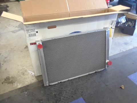 1985 Ford Bronco - A new radiator sits in its packaging, waiting to be installed in a vehicle.