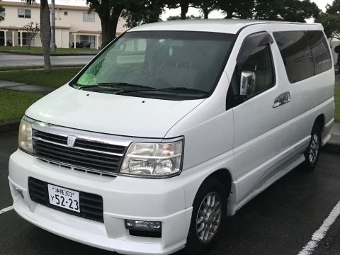 2002 Nissan Quest - A white minivan is parked on a wet asphalt surface, viewed from the front three-quarter angle.