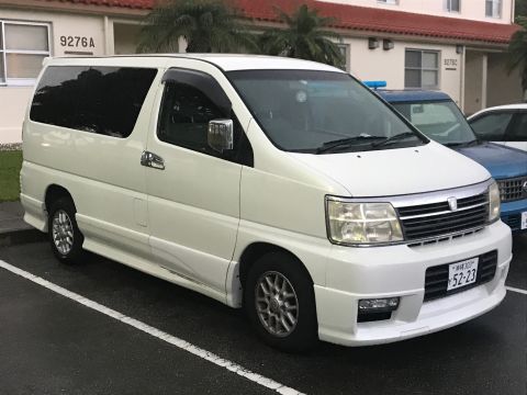 2002 Nissan Quest - A white minivan is parked in a lot next to another vehicle. The minivan has tinted windows and a chrome grille.