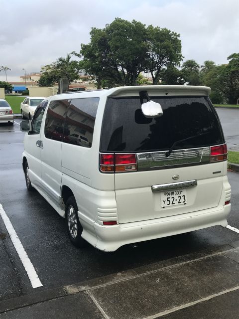 2002 Nissan Quest - A white minivan is parked in a lot on a cloudy day, showing its rear details and license plate.