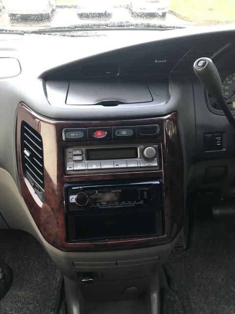 2002 Nissan Quest - Interior view of a 2002 Nissan Quest dashboard, wood grain trim and an aftermarket Kenwood stereo system.