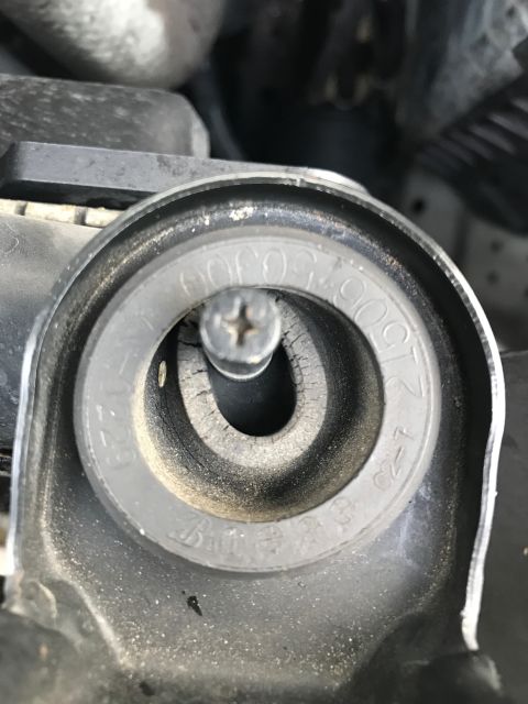 2002 Nissan Quest - This image shows a close-up of a vehicle's radiator cap housing, with some visible markings and a screw.