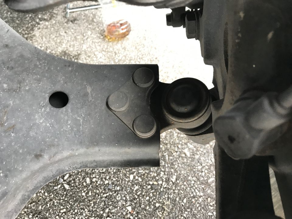 Close-up of a car's suspension linkage and ball joint assembly