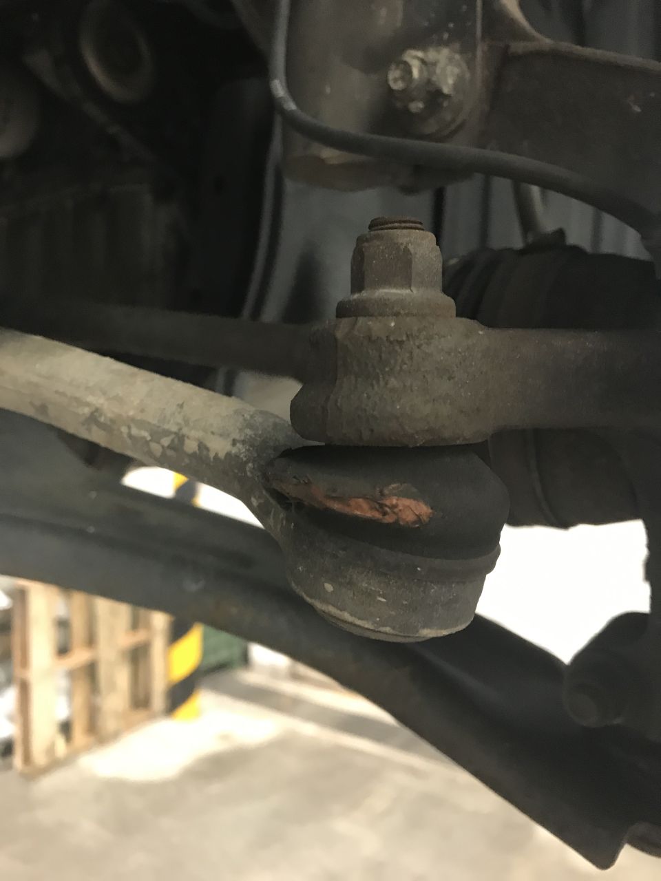 Worn ball joint with torn rubber boot on vehicle suspension