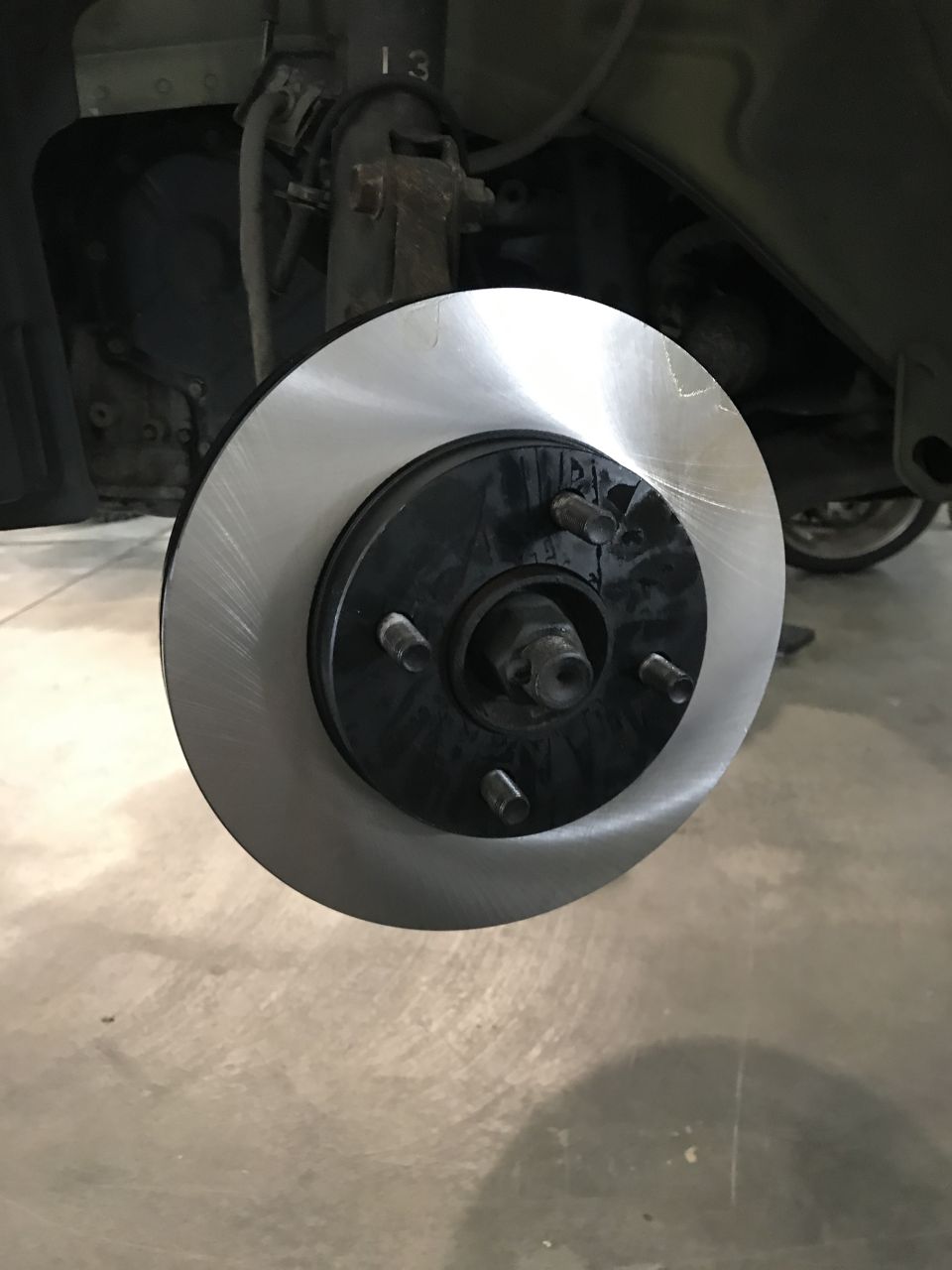 Close-up of a new car brake rotor on a hub