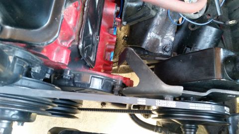 1985 Ford Bronco - A close-up view of the engine belt and pulleys on a Ford Bronco. The belts show text indicating they are made in the USA.