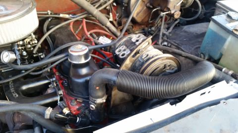 1985 Ford Bronco - A close-up view of the engine bay of a classic vehicle, showing the air filter, carburetor, hoses, and engine components.