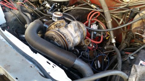 1985 Ford Bronco - The engine bay of a classic Ford Bronco shows a complex arrangement of hoses, wiring, and engine components, including a prominent air inta…