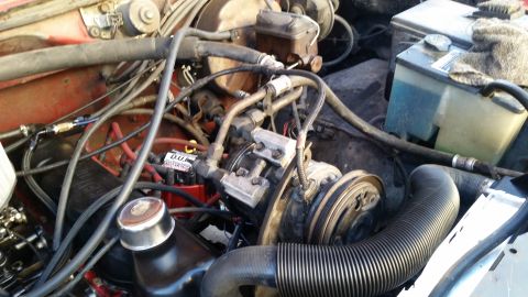 1985 Ford Bronco - This is a close-up view of the engine bay of a vehicle, showing various hoses, wires, the brake fluid reservoir, and the air conditioning c…