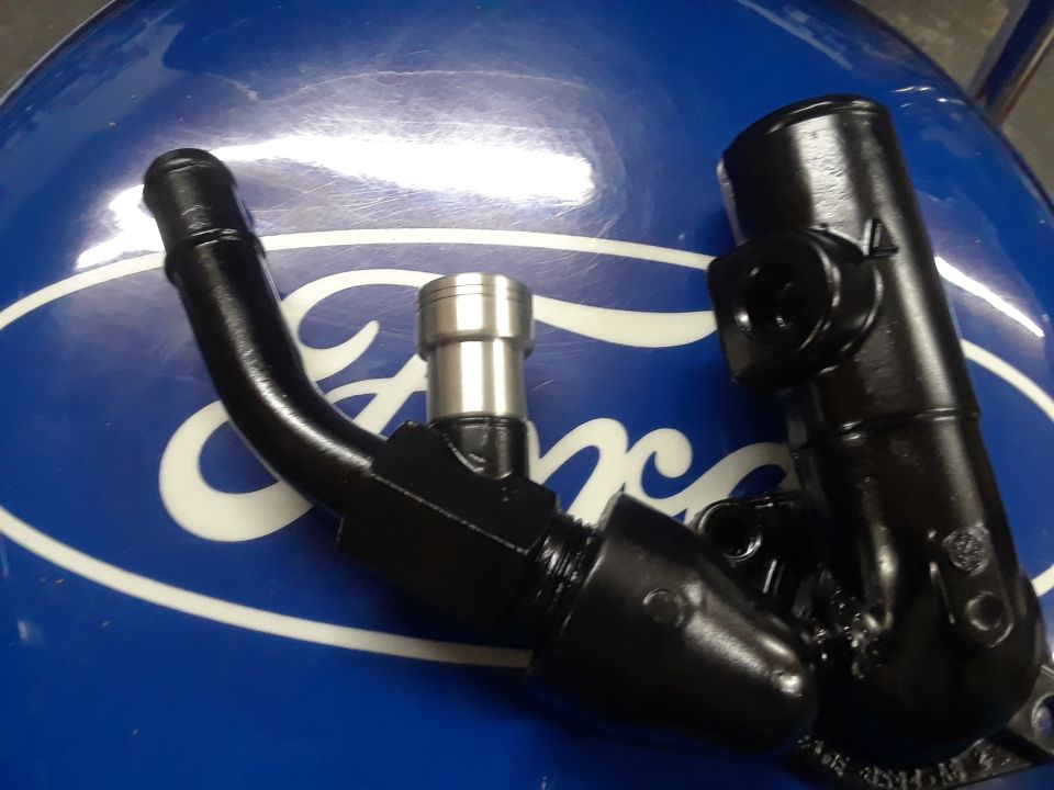 Black automotive parts on a blue surface with a Ford logo.
