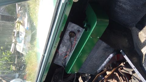 1991 Ford Bronco - The interior of a vehicle shows a green painted dashboard area with exposed wiring and a gauge cluster. Outside the vehicle, through the wi…