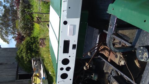 1991 Ford Bronco - A partially restored green and white vehicle chassis with exposed engine components and gear shifters is shown outdoors. The vehicle's fron…