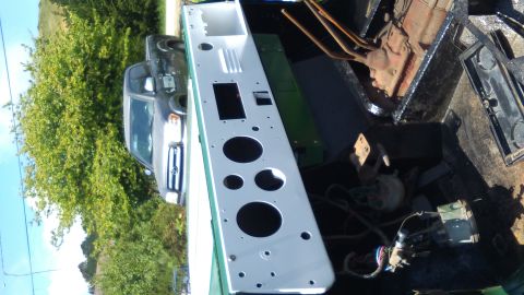 1991 Ford Bronco - A white dashboard panel with various circular cutouts is laid out in the bed of a dark-colored pickup truck. A dark gray SUV is parked behi…