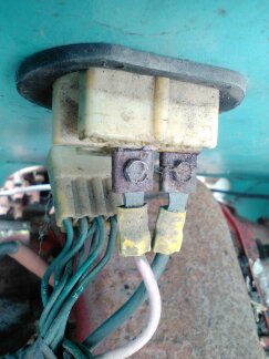 1991 Ford Bronco - A close-up view of a wiring harness connected to a cream-colored electrical connector. The wires are green and white, with yellow electrica…