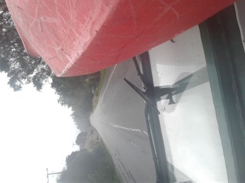 1991 Ford Bronco - A red kayak is mounted on the roof of a vehicle, seen from the driver's perspective looking out the windshield. The vehicle is driving on a…