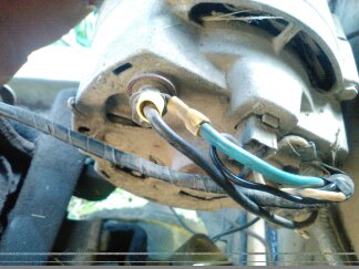 1991 Ford Bronco - Close-up view of electrical wiring connected to a component of a 1991 Ford Bronco. The wires are black, blue-green, and white, secured with…