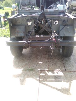1991 Ford Bronco - Rear view of a heavily modified, stripped-down vehicle, likely a 1991 Ford Bronco, with its rear body panels removed and suspension compone…