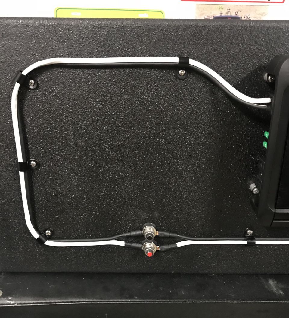 Black textured panel with wiring and two buttons.