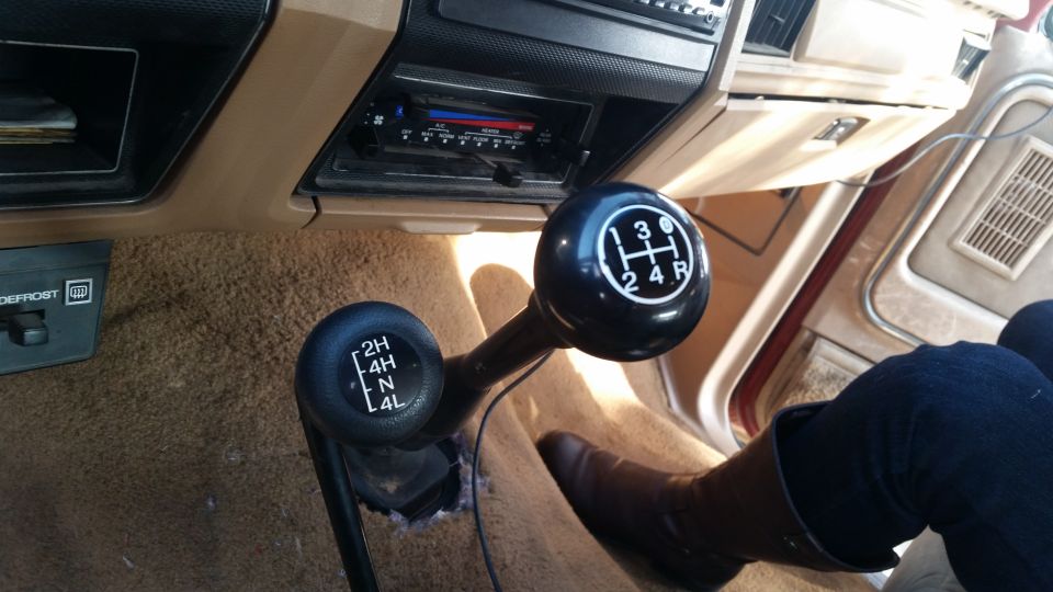 Interior of a vintage Ford Bronco showing transmission and 4x4 shifters.