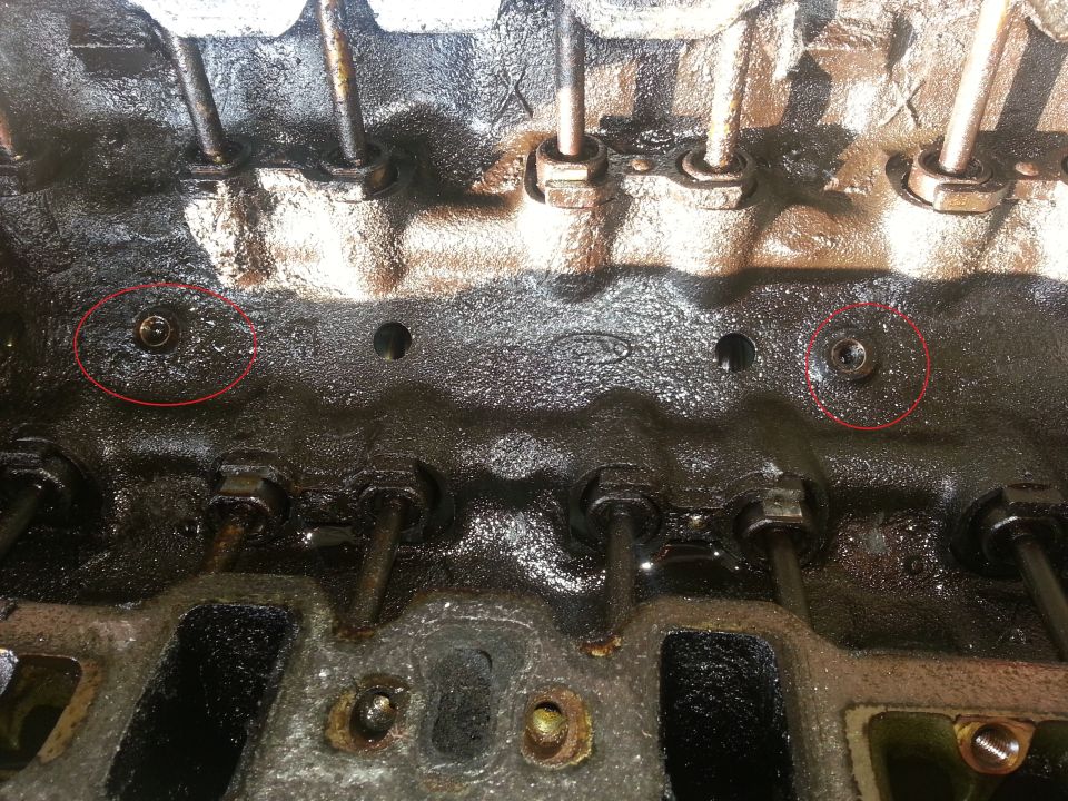 Photo of an engine cylinder head with valvetrain and circled bolt holes