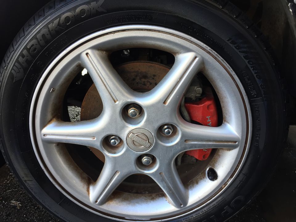 Silver five-spoke wheel with red brake caliper and Hankook tire.
