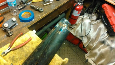 1978 Ford Bronco - A metal pipe, wire cutters, and blue tape are on a workbench next to a fire extinguisher and a red toolbox.