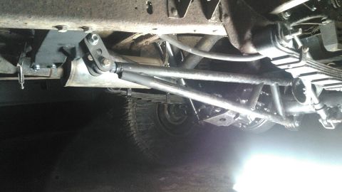 1978 Ford Bronco - Close-up of an aftermarket traction bar suspension system installed on the underside of a vehicle.