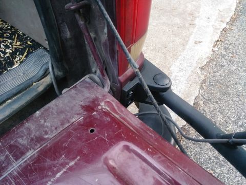 1996 Ford Bronco - Detail of a vehicle's rear, focusing on the tailgate and taillight area, with visible scuffs and dirt.
