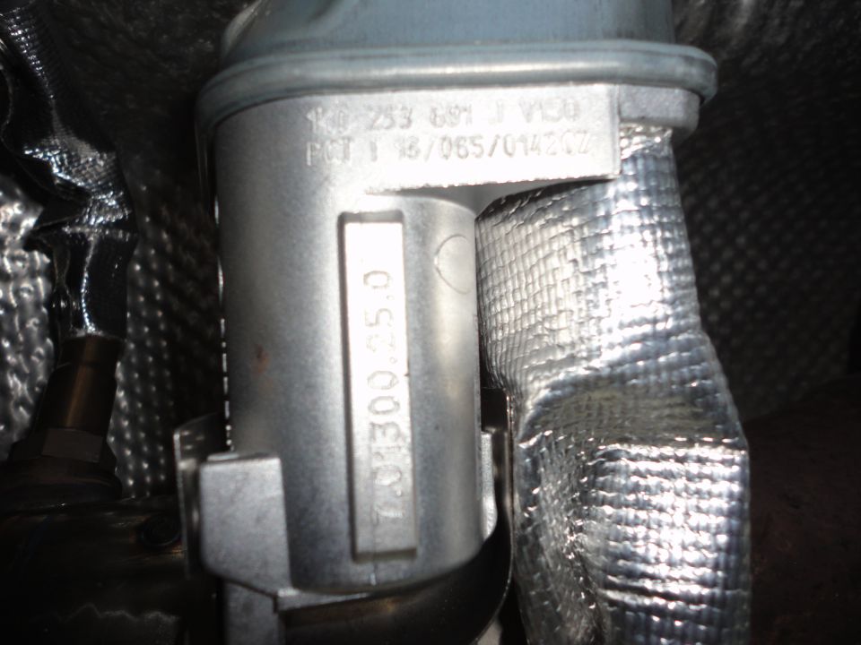 Cast metal underbody part stamped 1K0 253 691 J with aluminum heat shielding on a VW Jetta TDI