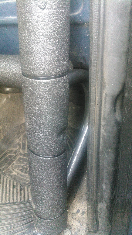 1978 Ford Bronco - Close-up of a padded roll cage structure inside a vehicle's interior.