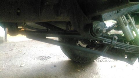 1978 Ford Bronco - Close-up of vehicle's rear suspension components, including leaf springs and shock absorber.