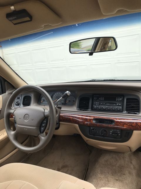1997 Mercury Grand Marquis - The interior of a 1997 Mercury Grand Marquis, a tan interior and wood grain accents on the dashboard.