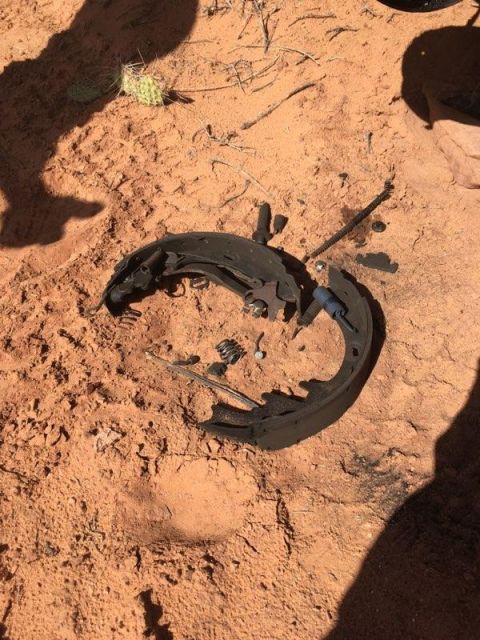 1995 Ford Bronco - A broken brake shoe assembly rests on the desert floor, indicating a vehicle malfunction.