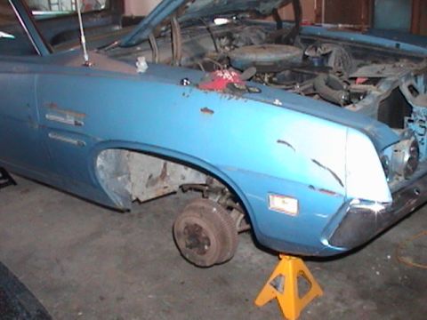 1971 Ford Ranchero - A blue 1971 Ford Ranchero is shown with its hood open and front passenger wheel removed, resting on an orange jack stand.