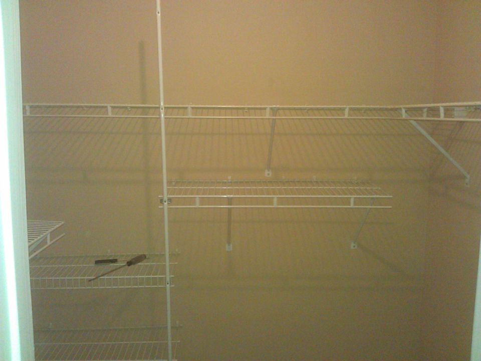 Empty closet with wire shelving and a screwdriver.