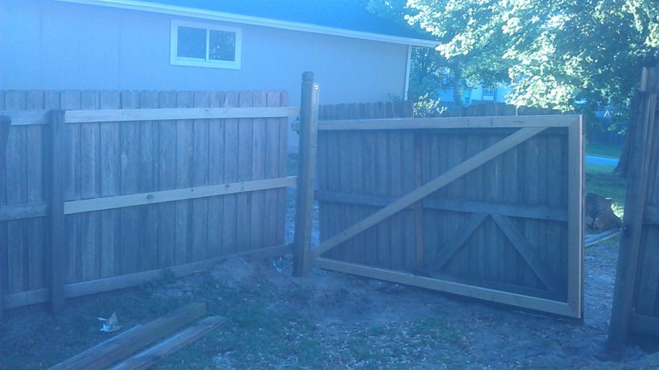 Wooden fence and gate in a backyard.
