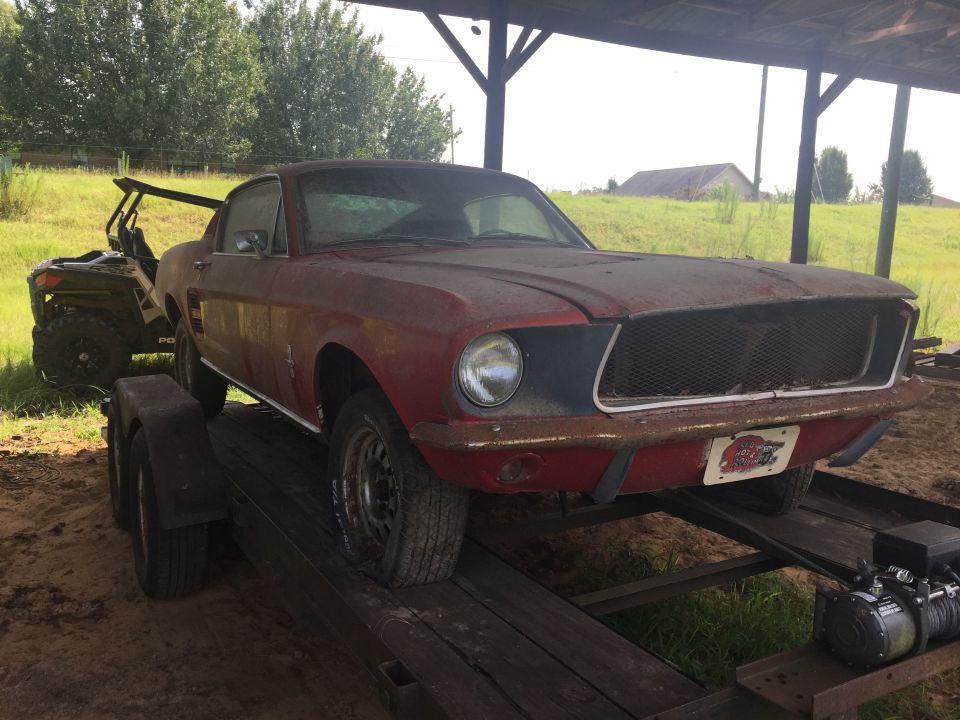 Red 1967 Ford Mustang coupe on a trailer with an ATV behind it.